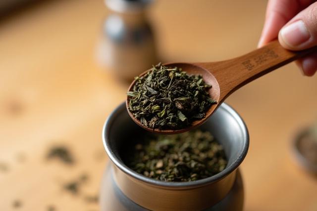 Teáskanálnyi tealevelek szűrőbe adagolása